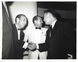 ["Black and white photograph print of Carl Albert shaking hands with an unidentified man."]