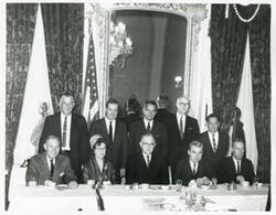 ["Black and white photograph print of Page Belcher, Ed Edmondson, John Jarman, Victor Wickersham, and Carl Albert standing. A. S. Mike Monroney, Tom Steed, Howard Edmondson, and two unidentified people are seated."]