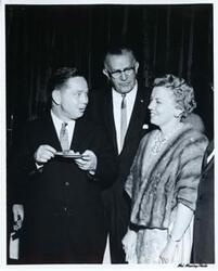 ["Black and white photograph print of Carl Albert posing with unidentified people."]