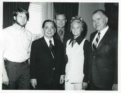 ["Black and white photograph print of Carl Albert posing with unidentified people."]