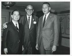 ["Black and white photograph print of Carl Albert posing with two unidentified men."]