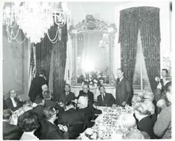 ["Black and white photograph print of Carl Albert, John W. McCormack, Richard M. Nixon, and Gerald R. Ford with several others seated at a dinner table."]