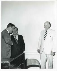 ["Black and white photograph print of Carl Albert and Robert L. F. Sikes. They are holding two plaques."]
