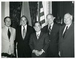 ["Black and white photograph print of Carl Albert, Gerald R. Ford and three other men posing for a picture. John Brademas is present in #3002."]