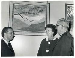 ["Black and white photograph print of Carl Albert speaking with Tom Steed and an unidentified woman in an art gallery."]