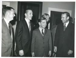 ["Black and white photograph print of Carl Albert standing with some astronauts."]