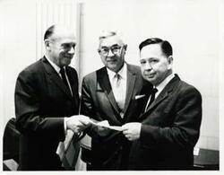["Black and white photograph print of Carl Albert posing with two unidentified men."]