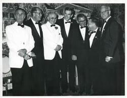 ["Black and white photograph print of Carl Albert, Mike Mansfield, Wright Patman, George Mahon, Wilbur D. Mills, and two other men posing for a picture. They are dressed in formal attire."]