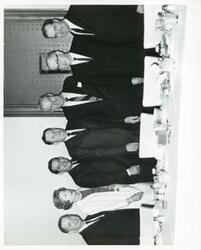 ["Black and white photograph print of Oklahoma delegation and others at a luncheon. L to R: Carl Albert, Mrs. Glenn McDonald, Fred Harris, Glenn McDonald, A. S. Mike Monroney, Tom Steed, and Ed Edmondson."]