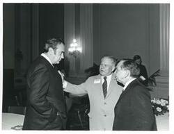 ["Black and white photograph print of Carl Albert speaking with Olin Teague at reception for freshman 94th Congress. December 1, 1975"]