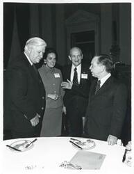 ["Black and white photograph print of Carl Albert and Thomas P. O'Neill speaking with two unidentified people at a reception for freshman members of the 94th Congress. December 1, 1975"]