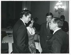 ["Black and white photograph print of Carl Albert speaking with Stephen Solarz and another person at a reception for freshman members of the 94th Congress. December 1, 1975"]