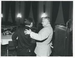 ["Black and white photograph print of Carl Albert speaking with Olin Teague at a reception for freshman members of the 94th Congress. December 1, 1975"]