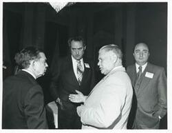 ["Black and white photograph print of Carl Albert speaking with Olin Teague at a reception for freshman members of the 94th Congress. December 1, 1975"]