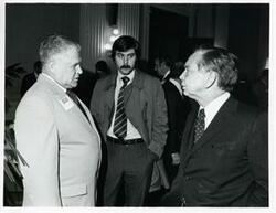 ["Black and white photograph print of Carl Albert speaking with Olin Teague and another man at a reception of freshman members of the 94th Congress. December 1, 1975"]