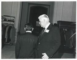 ["Black and white photograph print of Carl Albert speaking with Thomas P. O'Neill at a reception honoring freshman members of the 94th Congress. December 1, 1975"]