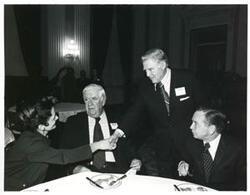 ["Black and white photograph print of Carl Albert with Thomas P. O'Neill and two others at a reception honoring freshman members of the 94th Congress. December 1, 1975"]