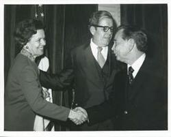 ["Black and white photograph print of Carl Albert shaking hands with an unidentified woman."]