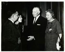 ["Black and white photograph print of Carl Albert and Mary Albert speaking with two unidentified men."]