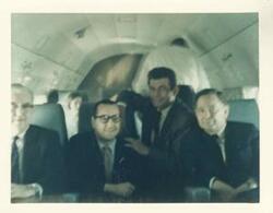 ["Color photograph print of Carl Albert, Tom Steed, and others in an airplane."]