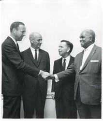 ["Black and white photograph print of Carl Albert standing with three unidentified men."]