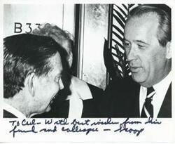 ["Black and white photograph print of Henry M. Jackson and Carl Albert talking to one another."]