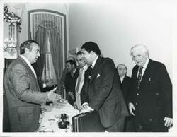 ["Black and white photograph print of Thomas P. O'Neill standing with several people at the Democratic leadership conference."]