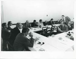 ["Black and white photograph print of Russell B. Long, Carl Albert, Robert Strauss, John Brademas, and others seated at dinner tables at the Democratic leadership conference."]