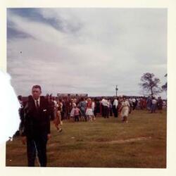 ["Black and white photograph print of John B. Connally, A. S. Mike Monroney, Lady Bird Johnson, Henry Bellmon, Carl Albert, Ed Edmondson, Lyndon B. Johnson, and others at the dedication of the Eufaula Dam and Reservoir by President Johnson. September 25, 1964. a-c color photo additions. Carl Albert at podium, Lyndon B. Johnson at podium, and crowd."]