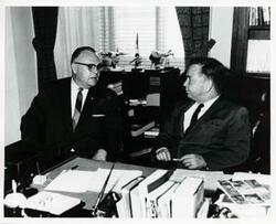 ["Black and white photograph print of Chamber of Commerce and Agriculture Manager Bob Wright and Carl Albert discussing development of the Arkansas River Basin."]