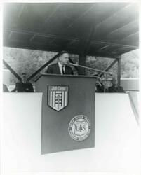 ["Black and white photograph print of Carl Albert speaking at a ceremony."]