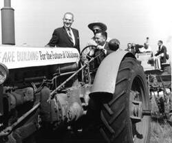 ["Black and white photograph print of Carl Albert driving a tractor at the Senior Citizens Housing groundbreaking ceremony. Oklahoma City. September 21, 1963"]
