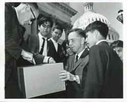 ["Black and white photograph print of photos A-C. Carl Albert with a group of young Indians outside the Capitol."]