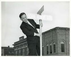 ["Black and white photograph print of photos A-C. Carl Albert installing the official road sign for the Carl Albert Parkway in McAlester, Oklahoma."]