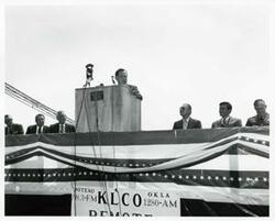 ["Black and white photograph print of Carl Albert speaking at the Port Carl Albert dedication. John N. Happy Camp, David Hall, and Wilbur D. Mills is also present. May 27, 1972"]