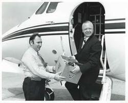 ["Black and white photograph print of G. L. Thompson presenting several items of surplus aviation equipment to Elmer King, Ground School instructor, Southeastern State College, Durant, Oklahoma."]