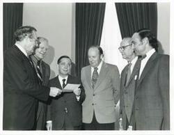 ["Black and white photograph print of presentation of $80,000 to Carl Albert for murals in Capitol. Fred Swengel and Gerald R. Ford are also present."]