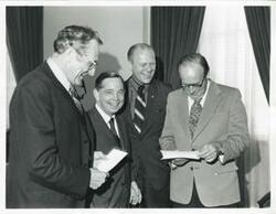 ["Black and white photograph print of presentation of $80,000 to Carl Albert for murals in Capitol. Fred Swengel and Gerald R. Ford are also present."]