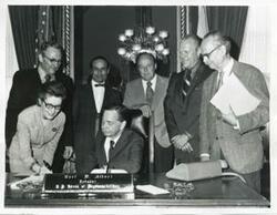 ["Black and white photograph print of presentation of $80,000 to Carl Albert for murals in Capitol. Fred Swengel and Gerald R. Ford are also present."]