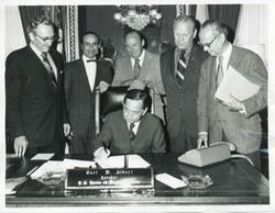 ["Black and white photograph print of presentation of $80,000 to Carl Albert for murals in Capitol. Fred Swengel and Gerald R. Ford are also present."]