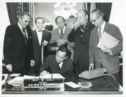 ["Black and white photograph print of presentation of $80,000 to Carl Albert for murals in Capitol. Fred Swengel and Gerald R. Ford are also present."]