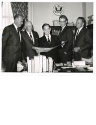 ["Black and white photograph print of Carl Albert, with four unidentified men, viewing a booklet on Talimena Scenic Drive"]