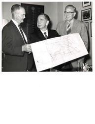 ["Two black and White photograph prints of Carl Albert and a two other unidentified men looking at a U.S. Army map in office"]