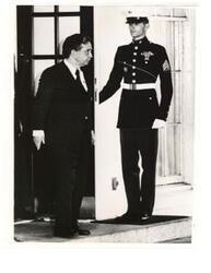["Black and white photograph print of Marine guard opening the door for Carl Albert at the White House."]