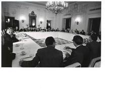 ["Black and White photograph of Bipartisan leadership meeting at the White House, President Nixon (center background) and Gerald Ford (left background). June 2, 1972"]