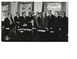 ["Black and White photograph of Lyndon B. Johnson with the Oklahoma delegation. Those present include: Carl Albert, Ed Edmondson, J. Howard Edmondson, John Jarman, A.S. Mike Monroney, Tom Steed, and Victor Wickersham. Note on back of photo labels this as, \"Invitation to Lake Eufaula Dedication.\""]
