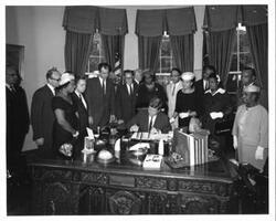 ["Black and White photograph of President John F. Kennedy signing S. 2399, An Act to provide for the establishment of the Frederick Douglass home as a part of the park system in the national capital and for other purposes"]