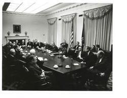 ["Black and White photograph of Lyndon B. Johnson and congressional leaders meeting in the cabinet at the White House. Carl Albert and Hubert Humphrey are present."]