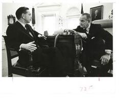 ["Black and White photograph of Lyndon B.  Johnson speaking with Carl Albert in the Oval Office."]