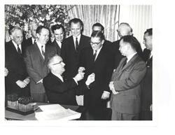 ["Black and white photograph, on stock paper, of Lyndon B. Johnson signing the tax bill in the president's office. Those pictured include:  Carl Albert, Everett M. Dirksen, Russell B. Long, John McCormack, and Wilbur D. Mills. Handwritten message identifying event, by unknown author, on back of photo."]